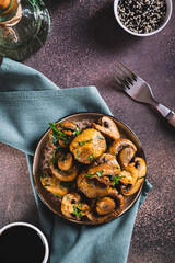 Homemade grilled mushrooms with herb on a plate on the table top and vertical view