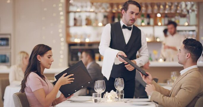 Couple on date in restaurant with menu, waiter and romantic evening together with fine dining service. Celebration of love, man and woman relax in luxury diner with server, Valentines and discussion