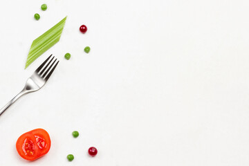 Fork, tomato, cranberry and celery stems on white background