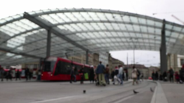 Public transportation station with people commuting, blurred establisher background