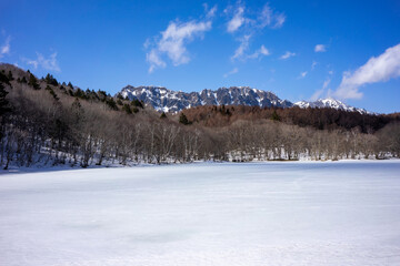 Expansive Snow Blanket in Front of Nagano's Rugged Mountains, a Contrast of Seasons.