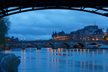 Conciergerie and Pont Neuf bridge over river Seine at night, Paris, France