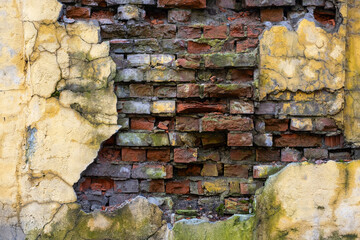 Old brick wall with peeling plaster