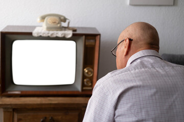 elderly man turns on and watches old retro analog TV with blank screen for designer, white...