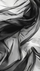 Fluttering chiffon and organza fabric in black and white. Translucent textiles with delicate movement.
