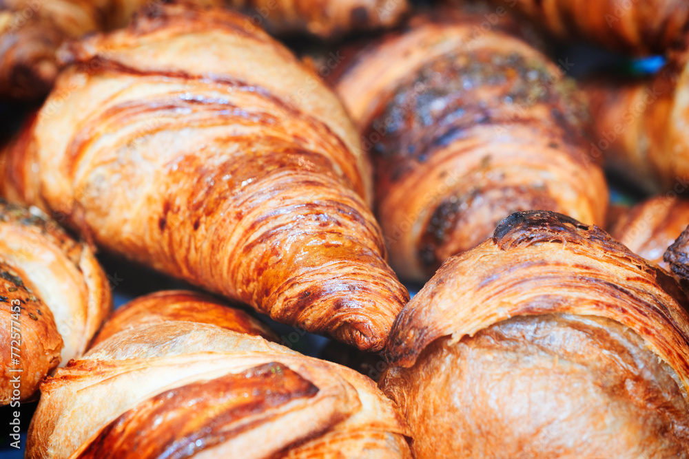 Poster a stack of croissants with a brown crust. the croissants are golden brown and have a crispy texture