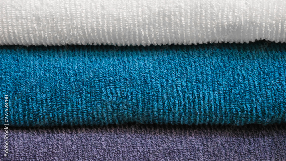 Leinwandbilder multi-colored textile towels lie in a stack on a shelf
