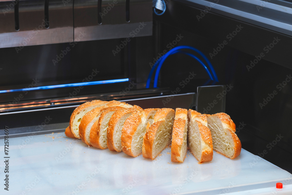 Poster A close up of a tray of bread with a few slices missing. The bread is toasted and has sesame seeds on it