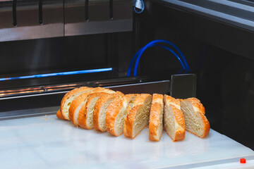 A close up of a tray of bread with a few slices missing. The bread is toasted and has sesame seeds on it