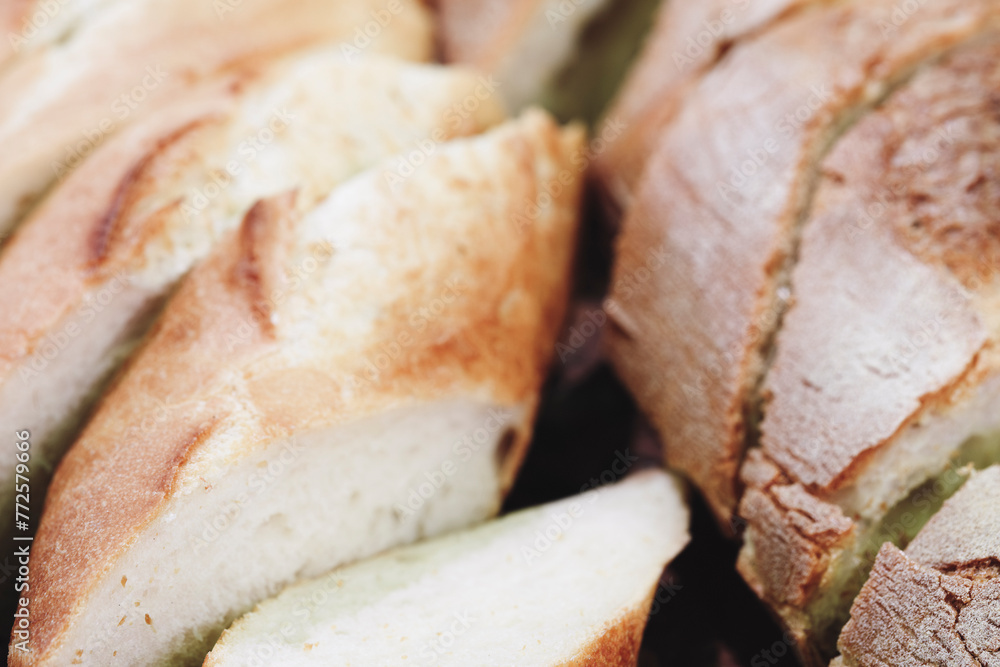 Poster a close up of a loaf of bread with a few slices missing. the bread is white and has a slightly brown