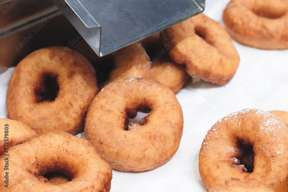Poster A stack of donuts with a brown glaze. The donuts are piled on top of each other, creating a visually appealing and appetizing display