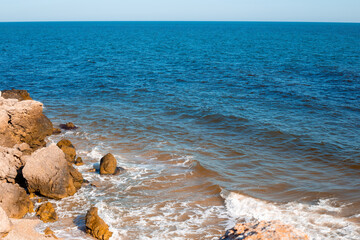 Seascape. Blue sea with rocky coast. The shore of the Sea of Azov in Crimea