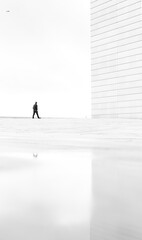 silhouette of a person walking along white architecture