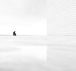 silhouette of a person in a wheelchair along white architecture - 772581051