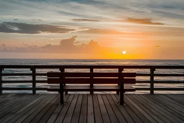 Gordijnen Unoccupied bench offers serene ocean view on pier © Jawed Gfx