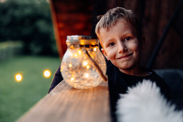 Portrait of an adorable little boy smiling holding a globe adorned with lights.