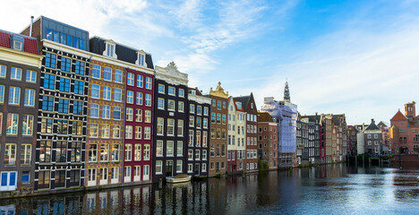 Amsterdam canal Singel with typical dutch houses and houseboats during morning blue hour, Holland,...