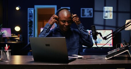 Portrait of african american man starting live broadcast on streaming platform, greeting viewers. Cheerful internet star arriving in studio, ready to create content for his audience
