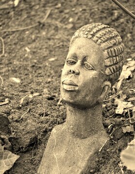 Afrikanischer Kopf aks Deko im Garten in Sepia