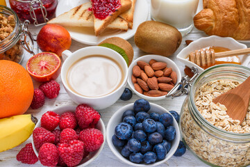 Healthy vegetarian breakfast buffet with various morning food. Oats, granola, croissant, coffee,...