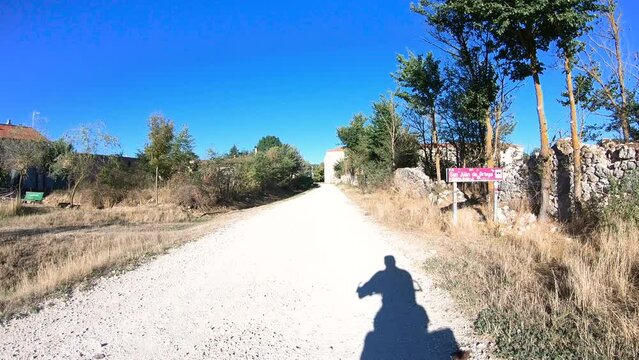 French Way of Saint James - a gravel road entering San Juan de Ortega, province of Burgos, Castile and Leon, Spain