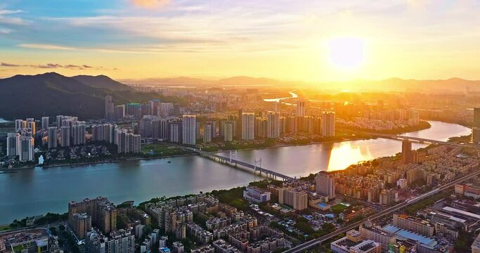 Aerial forward shot of modern city skyline and river nature landscape of Zhuhai at sunset