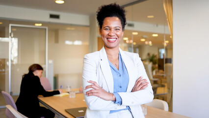 Portrait of a happy African American businesswoman standing at the office of her company