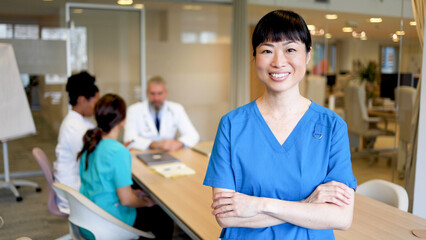 Portrait of a smiling young nurse attending a medical team meeting at the hospital conference room