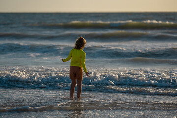 Kid running into sea water during summer holidays. Kid boy running along ocean. Child on summer beach. Child run a race in sea water. Kid running along sea water. Kid on sea summer vacation.