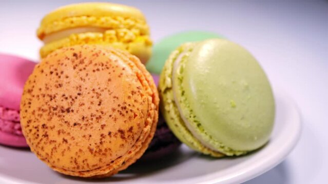 Close-up of colorful macarons cakes on white plate. macaroon desserts and sweets. sugar consumption