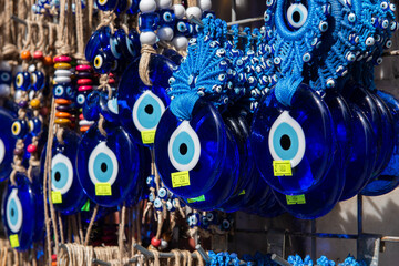 Nazar in market. Blue and red Fatima eye close-up protective amulet against evil eye. Israeli and...