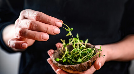 Girl hands holding bowl with microgreen sprouts