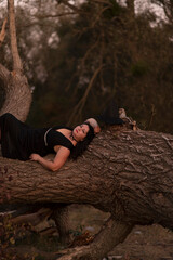 A witch dressed in black dress in the fores	