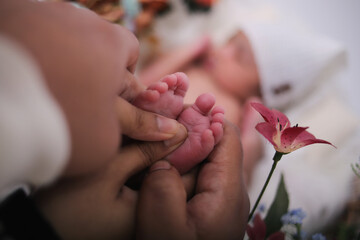 newborn photo shoot, parents are holding babies toes 