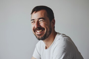 Portrait of a happy man laughing. Isolated on gray background.