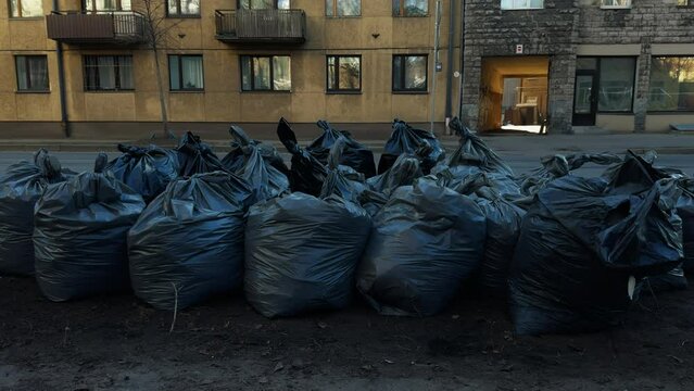 Trash bags littering the ground outside a city building