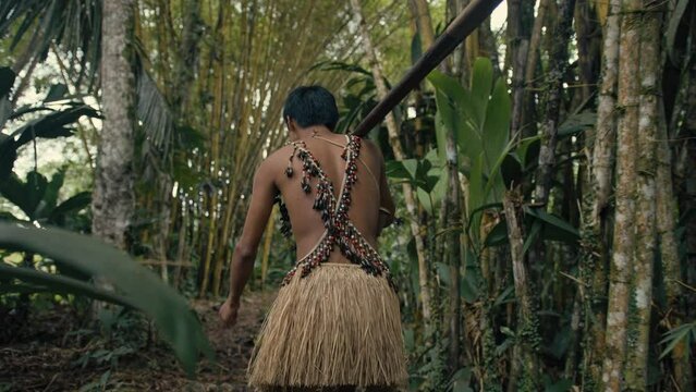 Young tribe man carrying a speak into the jungle