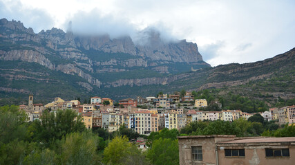 Views of the town of Monistrol de Montserrat, Bages, Barcelona, ​​Catalonia, Spain. Clouds over the summit of Montserrat Mountain, horizontal landscape with the village at its foot.