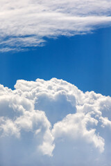Blue sky with puffy cloud formation in a shape of a heart, natural background