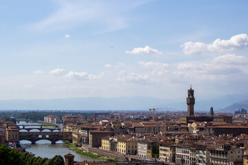 Breathtaking panorama over Florence, with the Arno River's bridges punctuating the city's historic architecture under a clear sky. - obrazy, fototapety, plakaty