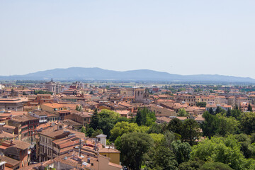 Fototapeta na wymiar The dense urban landscape of Pisa unfolds beneath a hazy sky, with the distant Tuscan hills framing the historic city.