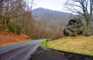 A landscape of a large boulder by a curved road in the mountains on the famous Blue Ridge Parkway...