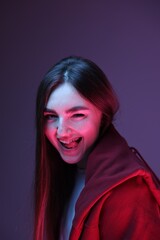 Portrait of happy woman on purple background in neon lights