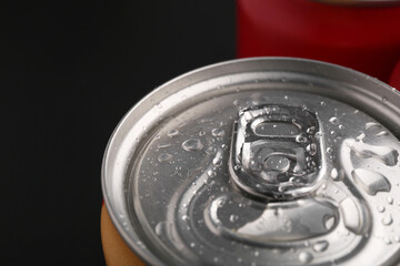 Energy drink in wet can on dark background, closeup