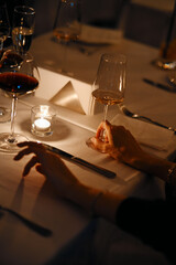people hold glasses of white and red wine in a night restaurant, celebrating