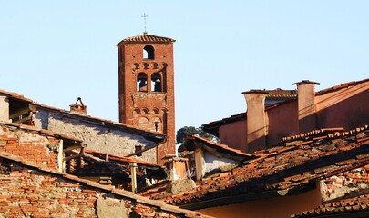 Antica torre in mattoni e tetti di vecchie case, Lucca, Italia