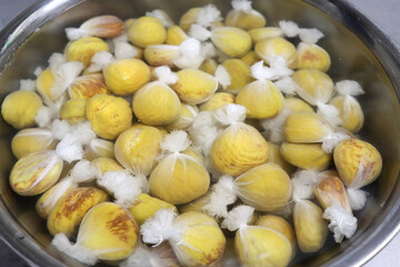 鍋で皮を剥いた黄色い栗を茹でる