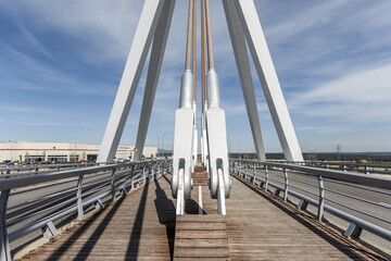 Image of the metal structure of a small bridge for road traffic and pedestrians on a day with bright skies