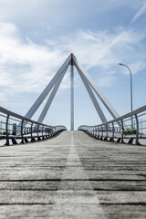 Metal structure of a small bridge with metal suspension structure, walkways and wooden floors for pedestrians