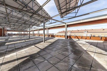 A large empty terrace in the attic of an office building with metal plates on a metal structure
